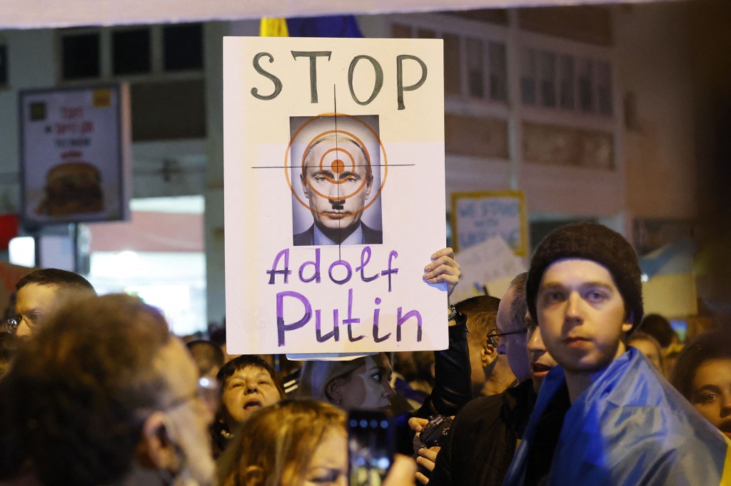 متظاهرون يحملون لافتات أمام السفارة الروسية في تل أبيب احتجاجًا على الغزو. 