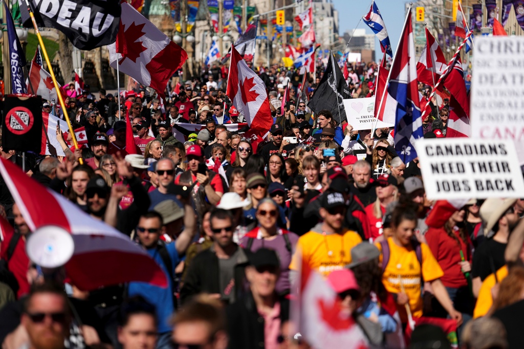 متظاهرون يجمعون الأعلام ويلوحون بها خلال مظاهرة في 30 أبريل 2022.