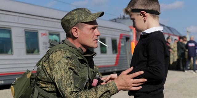 مجند روسي يتحدث إلى ابنه في محطة سكة حديد في برودبوي ، منطقة فولغوغراد في روسيا ، في 29 سبتمبر 2022.