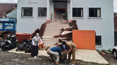 ضباط البلدية في سيانجور يخلون زميلاً مصاباً في أعقاب الزلزال.