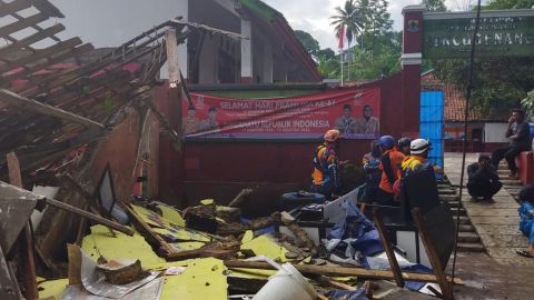 عمال يتفقدون مدرسة تضررت من الزلزال في سيانجور بجاوة الغربية.